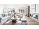 Sunlit living room showcasing hardwood floors, a modern fireplace, and abundant natural light through large windows at 11904 Spring Mill Rd, Carmel, IN 46032