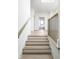 Bright stairway with wooden steps, modern black railings, and white trim at 11904 Spring Mill Rd, Carmel, IN 46032