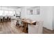 Open-concept dining area showcasing a wooden table, wicker chairs, and views into the modern kitchen at 127 Monon Green Blvd, Carmel, IN 46032