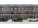 Charming brick townhomes featuring front patios and well-manicured landscaping add curb appeal at 127 Monon Green Blvd, Carmel, IN 46032