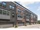 Exterior shot of townhomes, showcasing their brick facade, modern windows, gray trim and attached garages at 127 Monon Green Blvd, Carmel, IN 46032