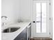 Stylish wet bar with marble countertops, stainless steel sink, beverage fridge, and outdoor access at 127 Monon Green Blvd, Carmel, IN 46032