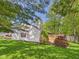 Landscaped backyard view with a white home, brick chimney, and mature trees, creating a private and peaceful outdoor space at 1356 S Catamaran Cir, Cicero, IN 46034