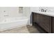 Modern bathroom featuring white tile, dark wood vanity, and stylish fixtures for a spa-like experience at 1356 S Catamaran Cir, Cicero, IN 46034