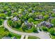Aerial view of a residential neighborhood showcasing lush green trees, manicured lawns, and a private pool at 13827 Driftwood Dr, Carmel, IN 46033
