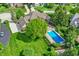 Aerial view of a beautiful home with a backyard pool, lush lawn, mature trees, and a long driveway at 13827 Driftwood Dr, Carmel, IN 46033
