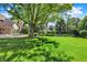 Expansive green backyard featuring lush grass, mature trees, manicured landscaping, and a black metal fence at 13827 Driftwood Dr, Carmel, IN 46033