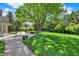 Large backyard with a lush green lawn, mature trees, and an inground pool at 13827 Driftwood Dr, Carmel, IN 46033