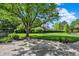 Lush backyard featuring well-manicured lawn, mature trees, and a spacious patio at 13827 Driftwood Dr, Carmel, IN 46033
