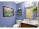 Stylish powder room with blue walls, a modern vanity, and decorative accents at 13827 Driftwood Dr, Carmel, IN 46033