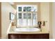 Bright bathroom with a soaking tub with garden window and wood trim at 13827 Driftwood Dr, Carmel, IN 46033