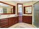 Bright bathroom with double sink vanity, dark wood cabinets, and a glass shower at 13827 Driftwood Dr, Carmel, IN 46033