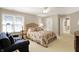 Well-lit bedroom with a floral bed, blue sofa, and a bright window at 13827 Driftwood Dr, Carmel, IN 46033