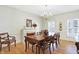 Bright dining room with chandelier, plantation shutters, and wooden table for six at 13827 Driftwood Dr, Carmel, IN 46033