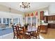 Warm dining room features hardwood floors, a chandelier, and a view into the kitchen and sunroom at 13827 Driftwood Dr, Carmel, IN 46033