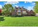 Beautiful two-story brick home with lush green lawn and mature trees on a sunny day at 13827 Driftwood Dr, Carmel, IN 46033