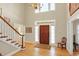 Inviting foyer features a wooden front door, chandelier, and staircase with white spindles at 13827 Driftwood Dr, Carmel, IN 46033
