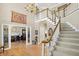 Elegant foyer with hardwood floors, staircase, chandelier, and dining room view at 13827 Driftwood Dr, Carmel, IN 46033