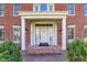 Classic front entrance with white columns, brick steps, and manicured shrubs at 13827 Driftwood Dr, Carmel, IN 46033