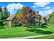 Traditional two-story brick home with lush front lawn, mature trees, and charming curb appeal at 13827 Driftwood Dr, Carmel, IN 46033