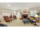 Bright living room with a brick fireplace, comfortable seating, and large windows with plantation shutters at 13827 Driftwood Dr, Carmel, IN 46033