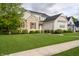 Attractive home with stone and brick, large lawn, and mature trees, blending elegance with natural beauty at 14003 Grannan Ln, Carmel, IN 46074