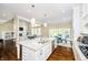 Open-concept kitchen features stainless appliances, a spacious island with seating, and hardwood floors that flow into living area at 14003 Grannan Ln, Carmel, IN 46074
