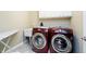 Modern laundry room with red washer, dryer, sink, and ironing board at 14003 Grannan Ln, Carmel, IN 46074