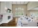 Bright living room featuring a fireplace, tall windows, and a comfortable white sectional sofa at 14003 Grannan Ln, Carmel, IN 46074