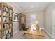 Inviting home office featuring built-in bookshelves, a large desk, and natural light at 14003 Grannan Ln, Carmel, IN 46074