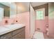 Retro bathroom with pink tiling, a vanity, and a shower-tub combination at 1409 Alimingo Dr, Indianapolis, IN 46260
