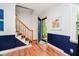 Bright entryway with wood floors, navy blue wainscoting, and staircase at 1409 Alimingo Dr, Indianapolis, IN 46260