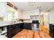 Kitchen featuring white upper cabinets, stainless steel oven, and wood flooring at 1409 Alimingo Dr, Indianapolis, IN 46260
