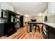 Open-concept kitchen featuring stainless steel refrigerator, bar seating, and wood floors at 1409 Alimingo Dr, Indianapolis, IN 46260