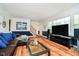 Bright living room featuring wood floors, leather sofa, and staircase access at 1409 Alimingo Dr, Indianapolis, IN 46260