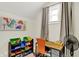 Charming bedroom with natural light, playful dinosaur wall decor, and a desk area for study or creative projects at 1421 Laurel St, Indianapolis, IN 46203