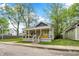 Charming home with a welcoming front porch, complemented by well-maintained landscaping and a yellow door at 1421 Laurel St, Indianapolis, IN 46203