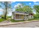 Charming home with a welcoming front porch, complemented by well-maintained landscaping and a yellow door at 1421 Laurel St, Indianapolis, IN 46203