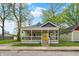 Charming home with a large front porch and vibrant yellow door adding curb appeal at 1421 Laurel St, Indianapolis, IN 46203