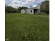 Cozy home with light green siding, red door and an attached shed, on a large grassy lot perfect for outdoor enjoyment at 1503 E 20Th St, Muncie, IN 47302