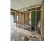 Partially gutted living room with exposed framing, plumbing, and pink insulation showing renovation potential at 1503 E 20Th St, Muncie, IN 47302