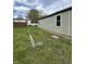 The side view of the property features a light green sided home and a overgrown area at 1503 E 20Th St, Muncie, IN 47302