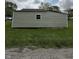 Exterior side view of home with light green siding showing some damage to the structure at 1503 E 20Th St, Muncie, IN 47302
