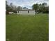 The home's side exterior reveals light green siding and a big lawn, offering potential for personalization and outdoor enjoyment at 1503 E 20Th St, Muncie, IN 47302