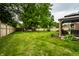 Green back yard featuring a well-maintained lawn, wood fence, and landscaping at 15203 Shoreway Ct, Carmel, IN 46032