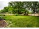 Large back yard with a manicured lawn, a wooden fence, and mature trees at 15203 Shoreway Ct, Carmel, IN 46032