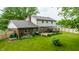 View of a backyard with a well-maintained lawn, patio with gazebo, landscaping, wooden fence, and mature trees at 15203 Shoreway Ct, Carmel, IN 46032