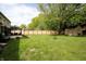 Spacious backyard featuring a large lawn, storage shed, patio, wooden fence, and mature trees at 15203 Shoreway Ct, Carmel, IN 46032