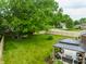 Backyard with mature trees, a wooden fence, green grass, and gazebo with outdoor seating, providing a private retreat at 15203 Shoreway Ct, Carmel, IN 46032