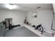 Finished basement with exercise equipment, including treadmill and rowing machine, and grey padded floor at 15203 Shoreway Ct, Carmel, IN 46032